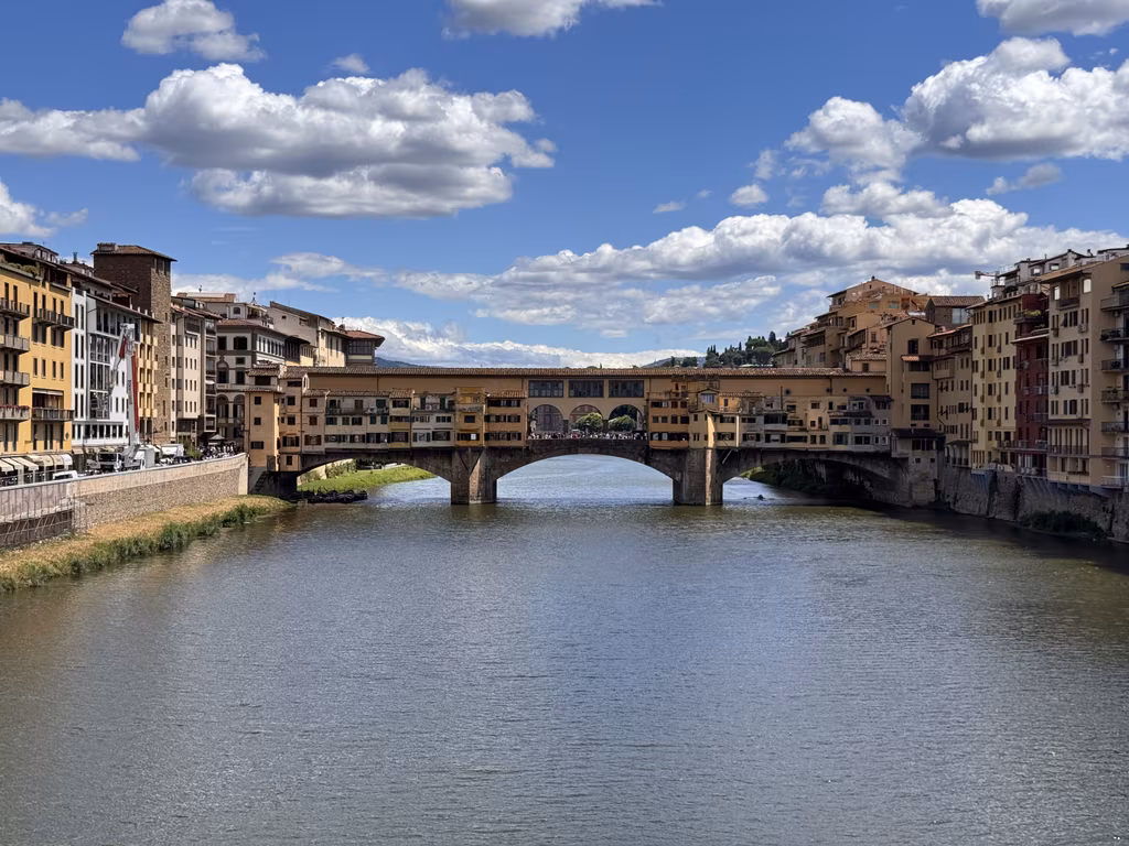 Ponte Vecchio crossing the Arno beneath a blue sky