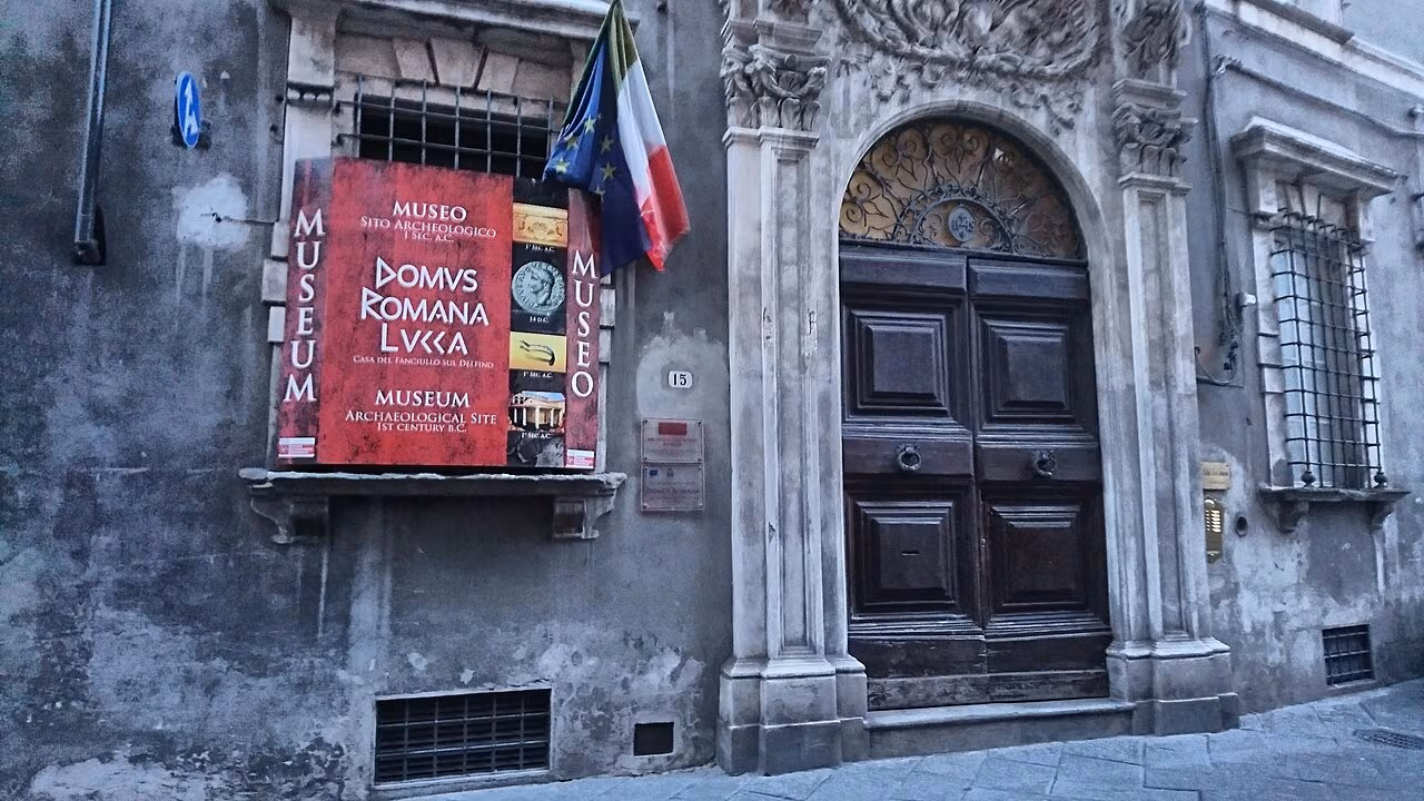 The entrance to the Domus Romana archaeological museum in Lucca, beside its red museum sign