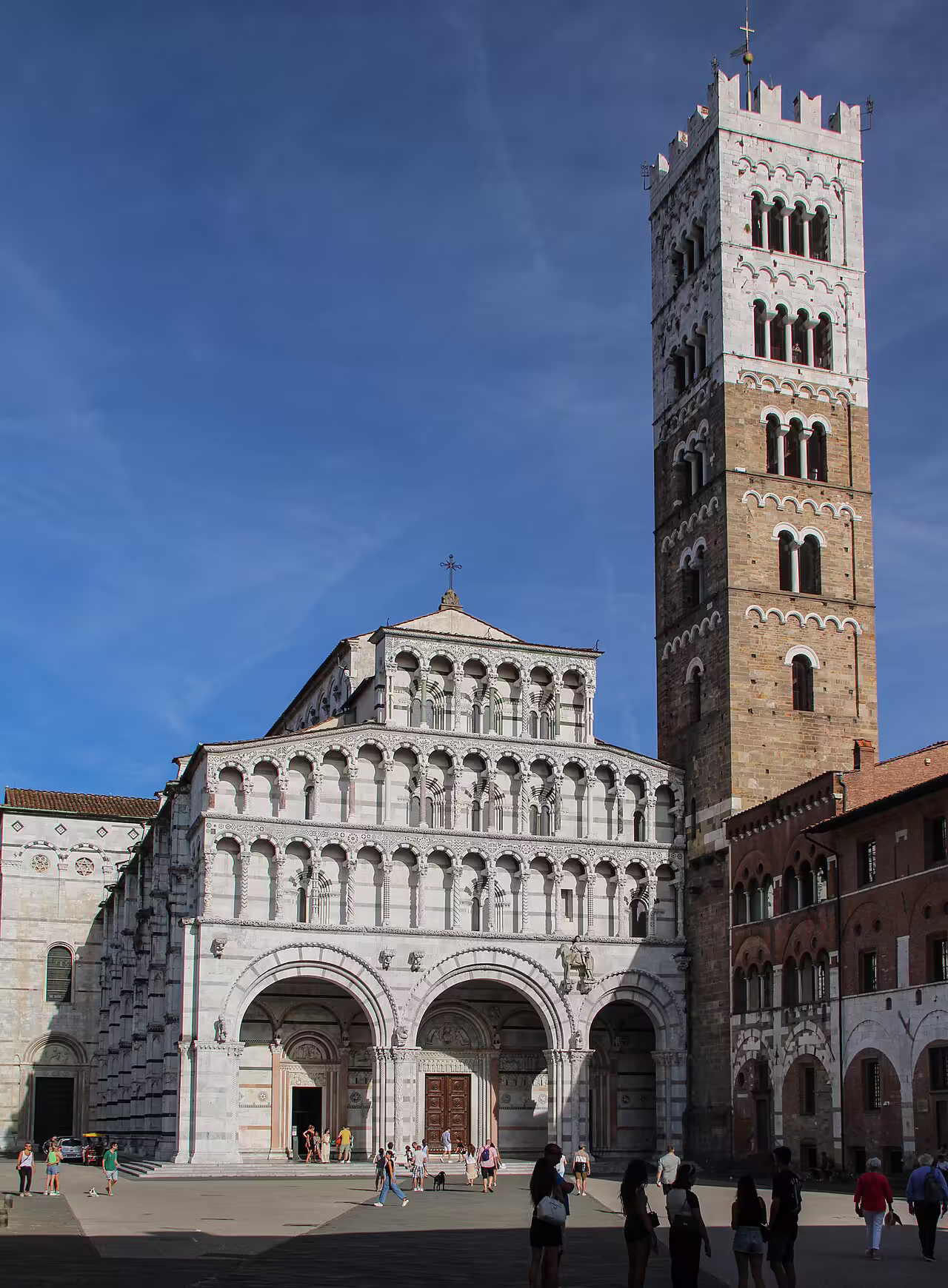 The asymmetrical facade of the Duomo di San Martino in Lucca, squeezed against its bell tower