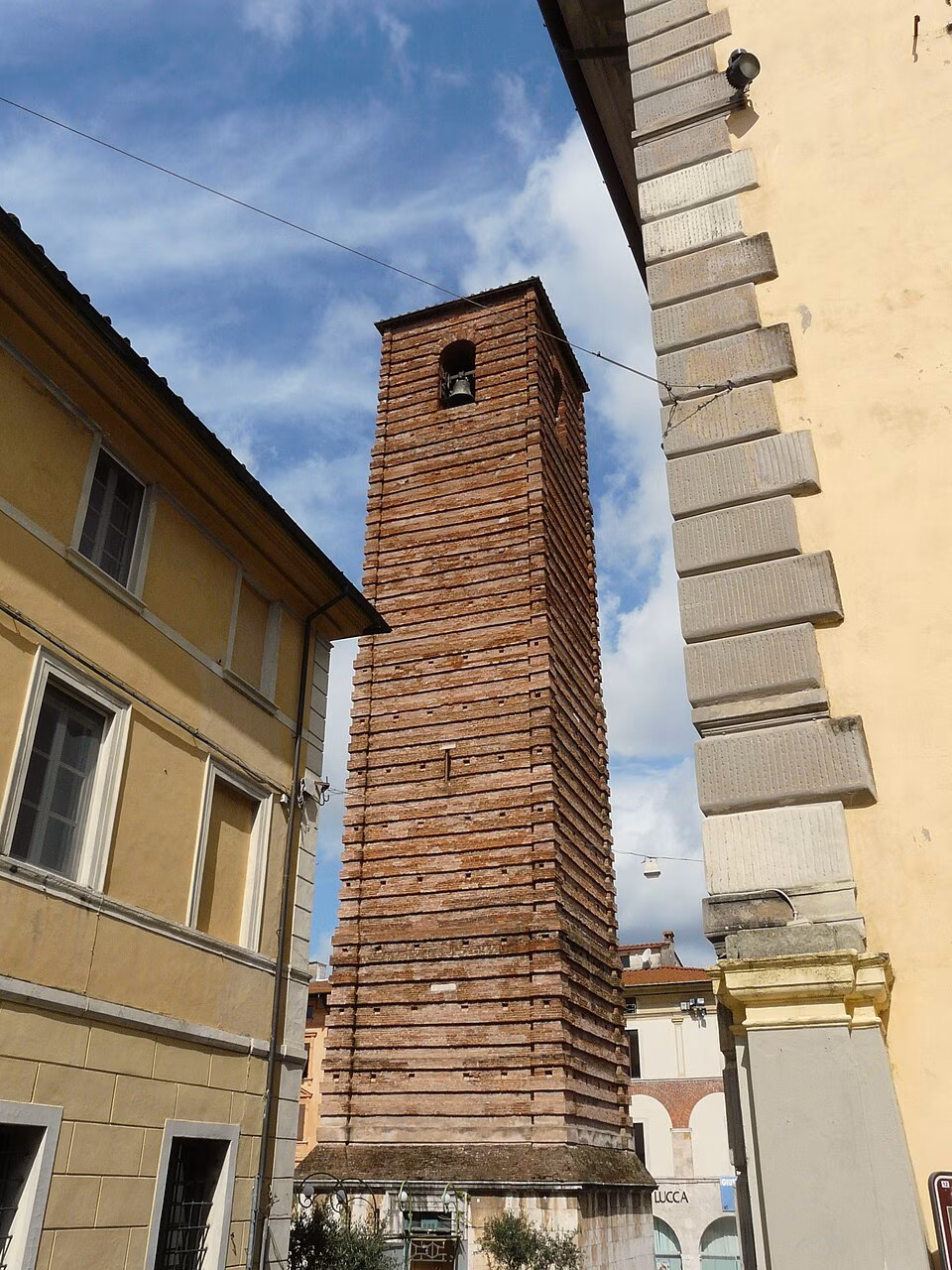 The brick bell tower of Pietrasanta Cathedral seen from Piazza del Centauro