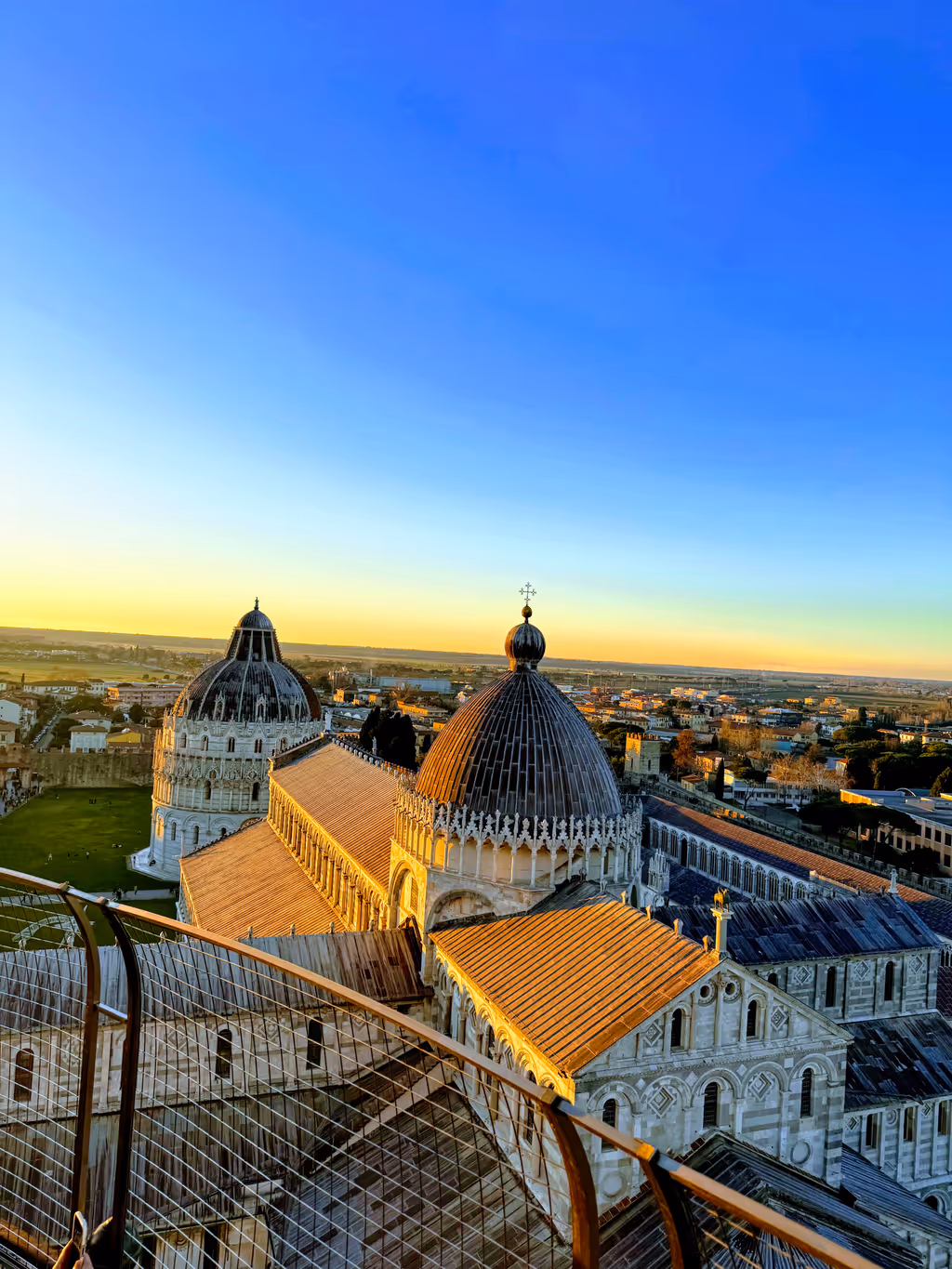 The Cathedral roof, the Baptistery dome and the Pisan plain seen from the top of the Leaning Tower at sunset