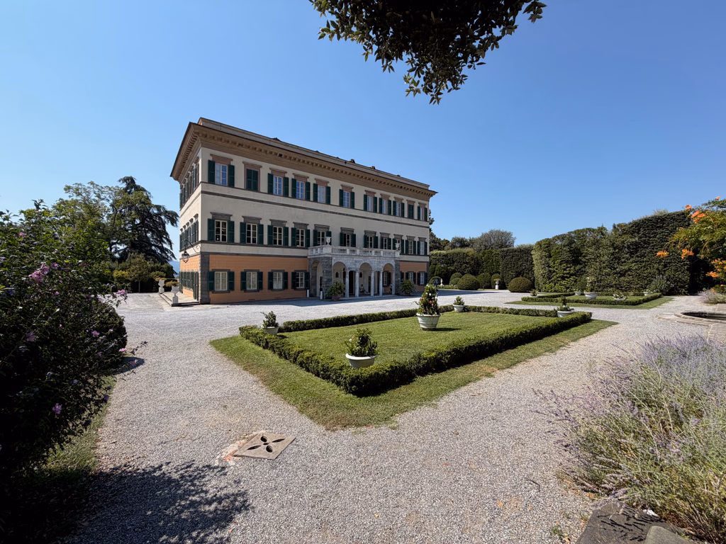 Villa Reale di Marlia and its formal forecourt garden beneath a clear blue sky