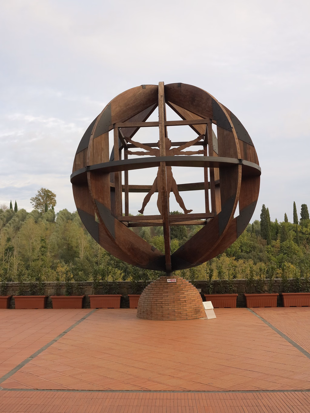 Mario Ceroli’s wooden Vitruvian Man sculpture on a terrace overlooking the hills of Vinci